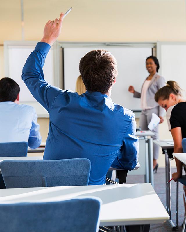 Student in classroom raising their hand
